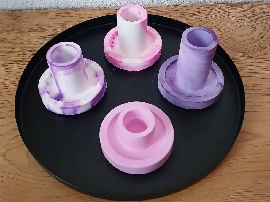 Colorful candle holders on a black tray.