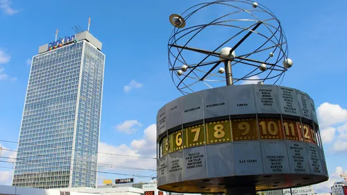 Weltzeituhr auf Stadtplatz mit Wolkenkratzer.