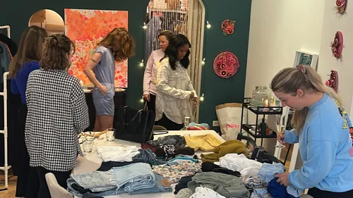 People sorting clothes in a stylish room.
