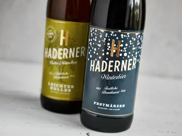 Two beer bottles are placed side by side on a table.