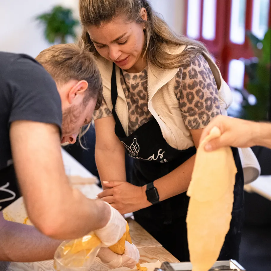 People making pasta in a kitchen.