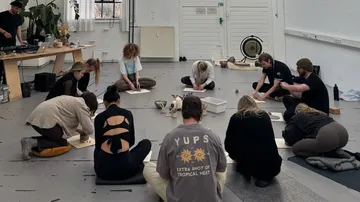 Group kneeling and working in a spacious room.