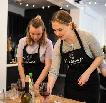 Zwei Frauen bereiten Essen in einer Küche vor.