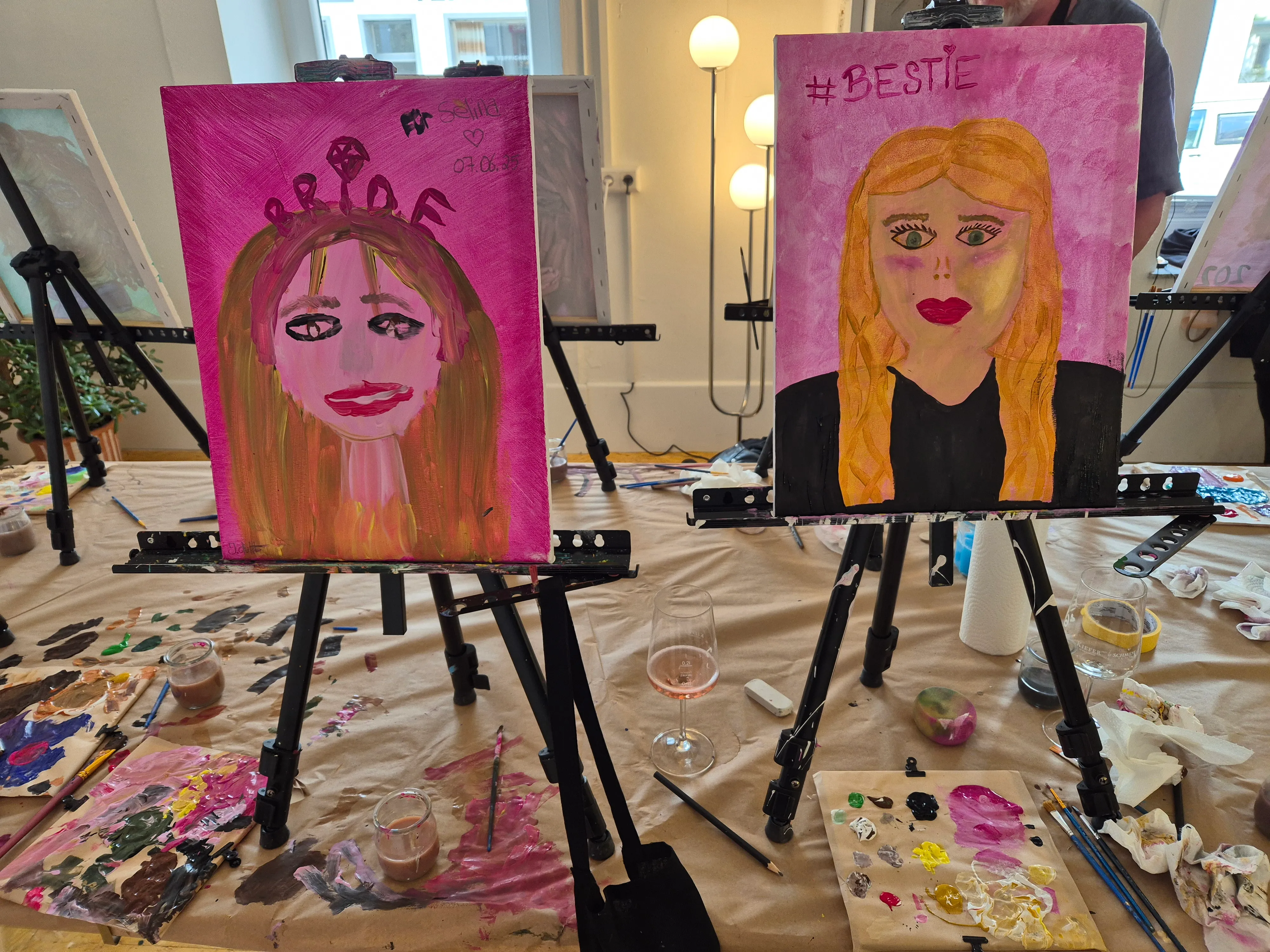 Two painted portraits on easels indoors.