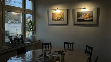 Kunststudio mit Gemälden an der Wand und Tisch.