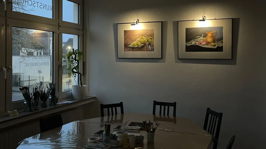 Kunststudio mit Gemälden an der Wand und Tisch.