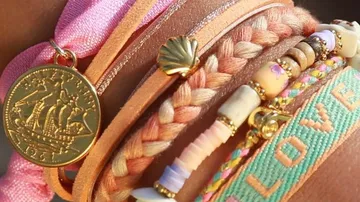 Colorful bracelets stacked on a wrist.