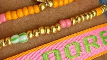 Beaded bracelets and colorful embroidery on wrist.