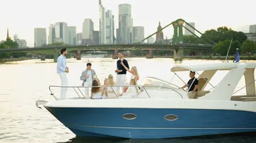 Gruppe genießt Yachtfahrt nahe Stadtsilhouette.