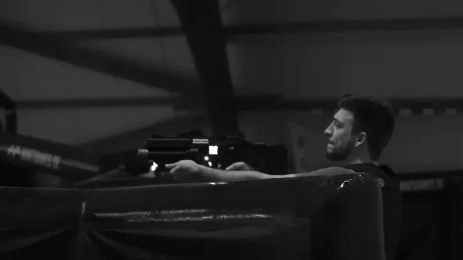 Person playing laser tag indoors, aiming forward.