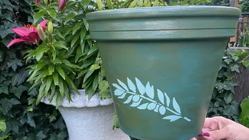 Handbemalter grüner Topf mit Blattdesign im Freien.