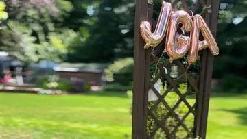 Ballons mit Aufschrift 'JGA' auf Gartenspalier.