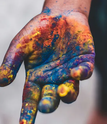 Colorful paint-covered hand in close-up view.