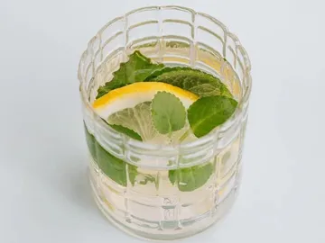 Ein Glas mit Wasser, Minze und Zitronenscheiben.