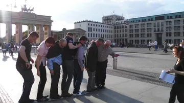 People standing on newspapers in city square.