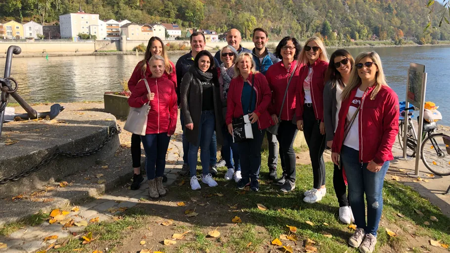 Group of people posing by a riverbank.