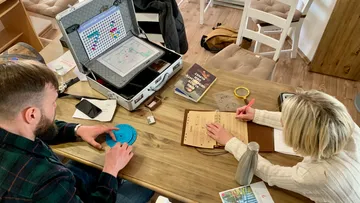 Two people solving puzzles at a table.
