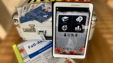 Tablet displaying menu with case and documents nearby.