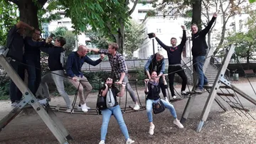 Gruppe von Menschen spielt auf einem Klettergerüst.