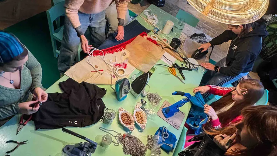 People crafting clothes on a table together.