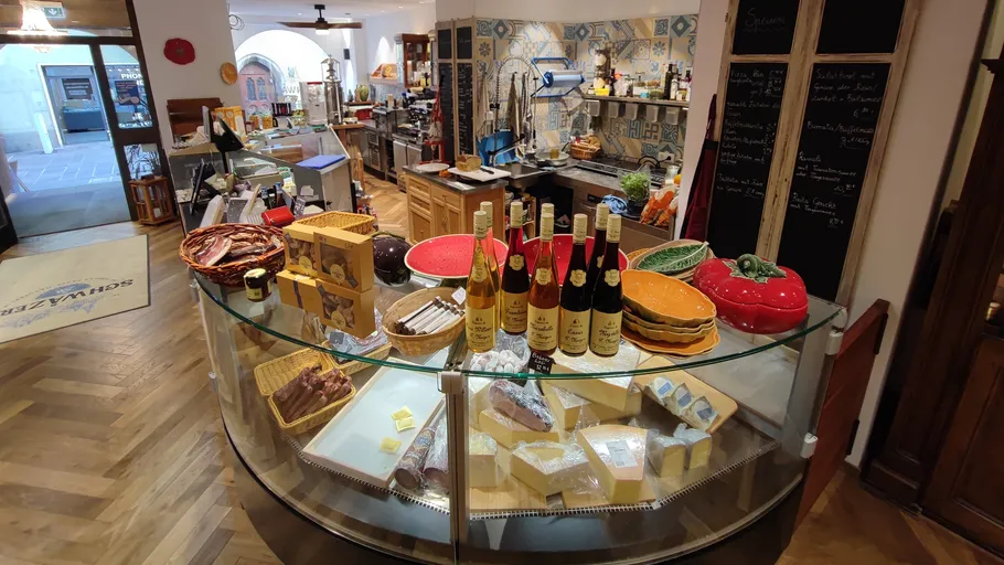 Assorted cheeses and wines on circular glass display.