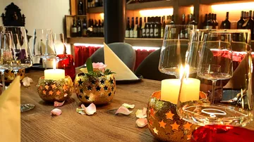 Table with candles and wine glasses in restaurant.