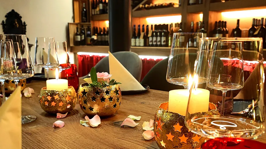 Table setting with candles and wine glasses.