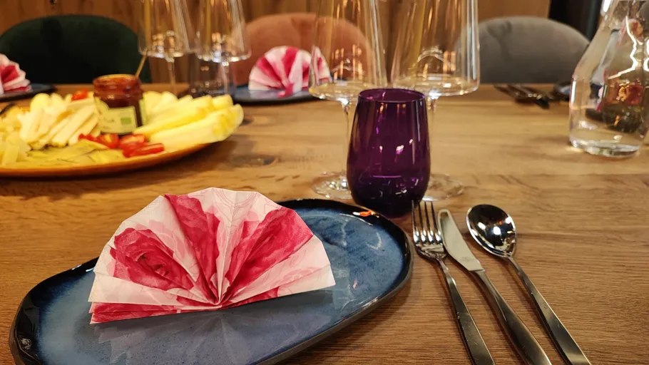 Napkin folded on plate with cutlery nearby.