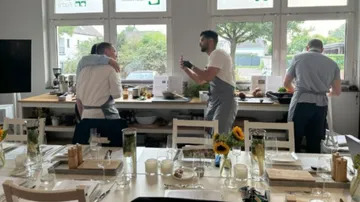 Three chefs preparing food in a kitchen.