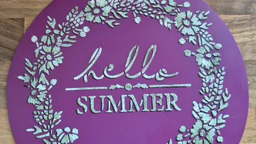 Lila Schild mit 'hello SUMMER' und Blumendesign.