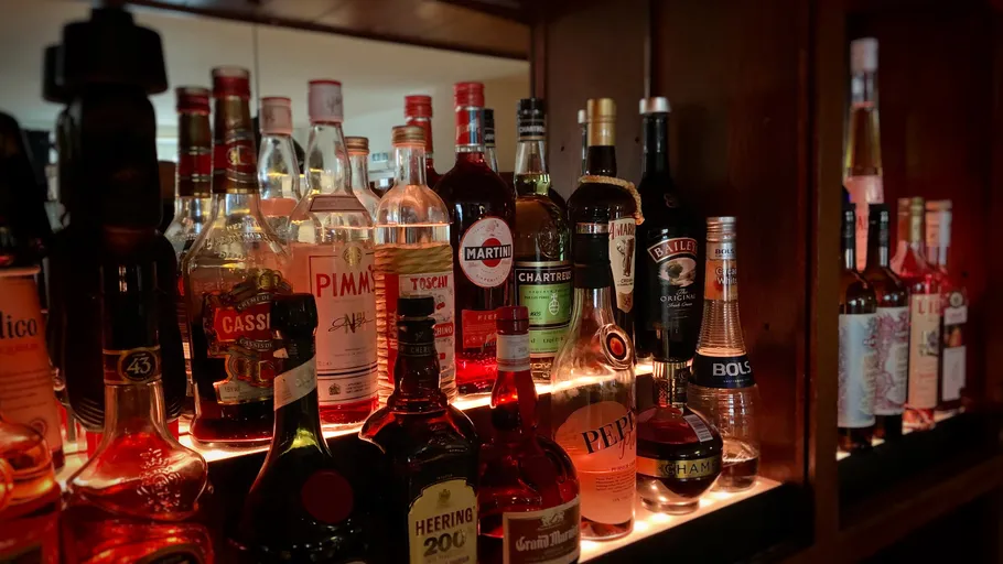 Various liquor bottles on a bar shelf.