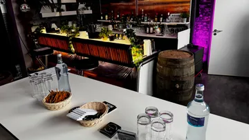 Bar mit Hockern, Getränken und Snacks eingerichtet.