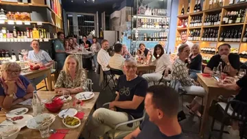 Gruppe von Menschen speist in einem Weinladen.