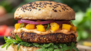 Veggie burger with mango salsa and arugula.