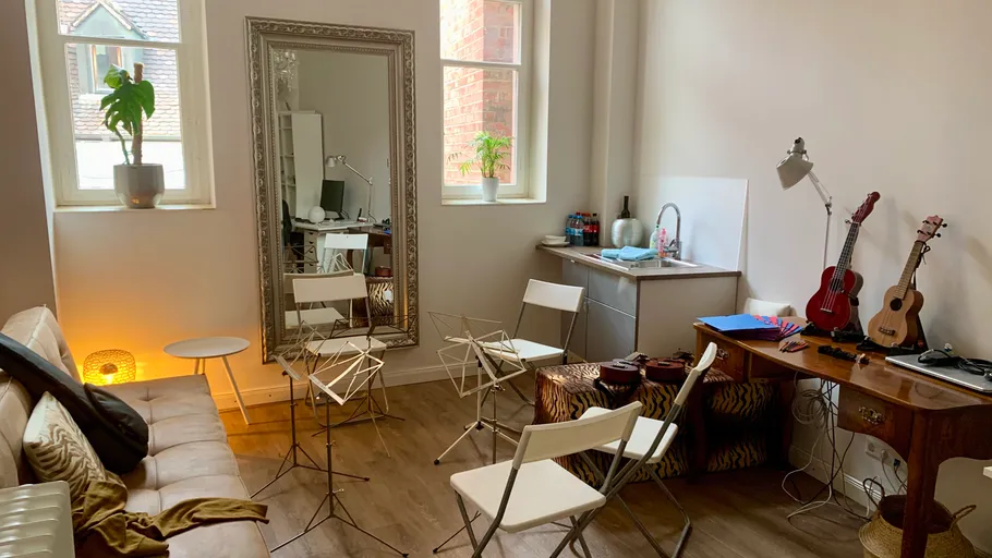 Indoor music room with guitars and chairs.