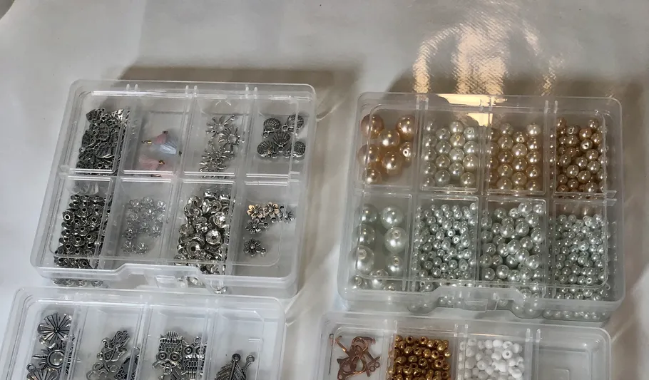 Three boxes of assorted beads and clasps.