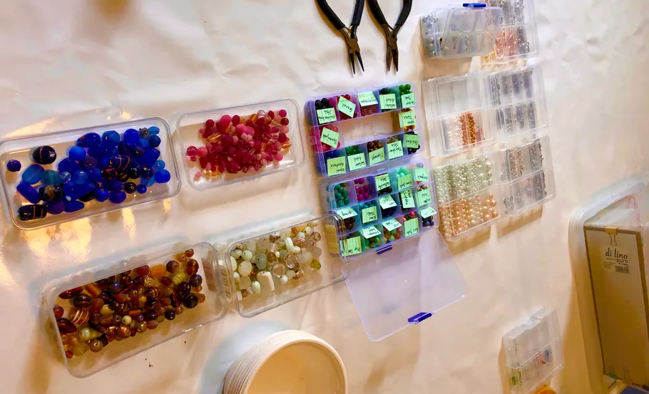 Beads organized in containers on a table.