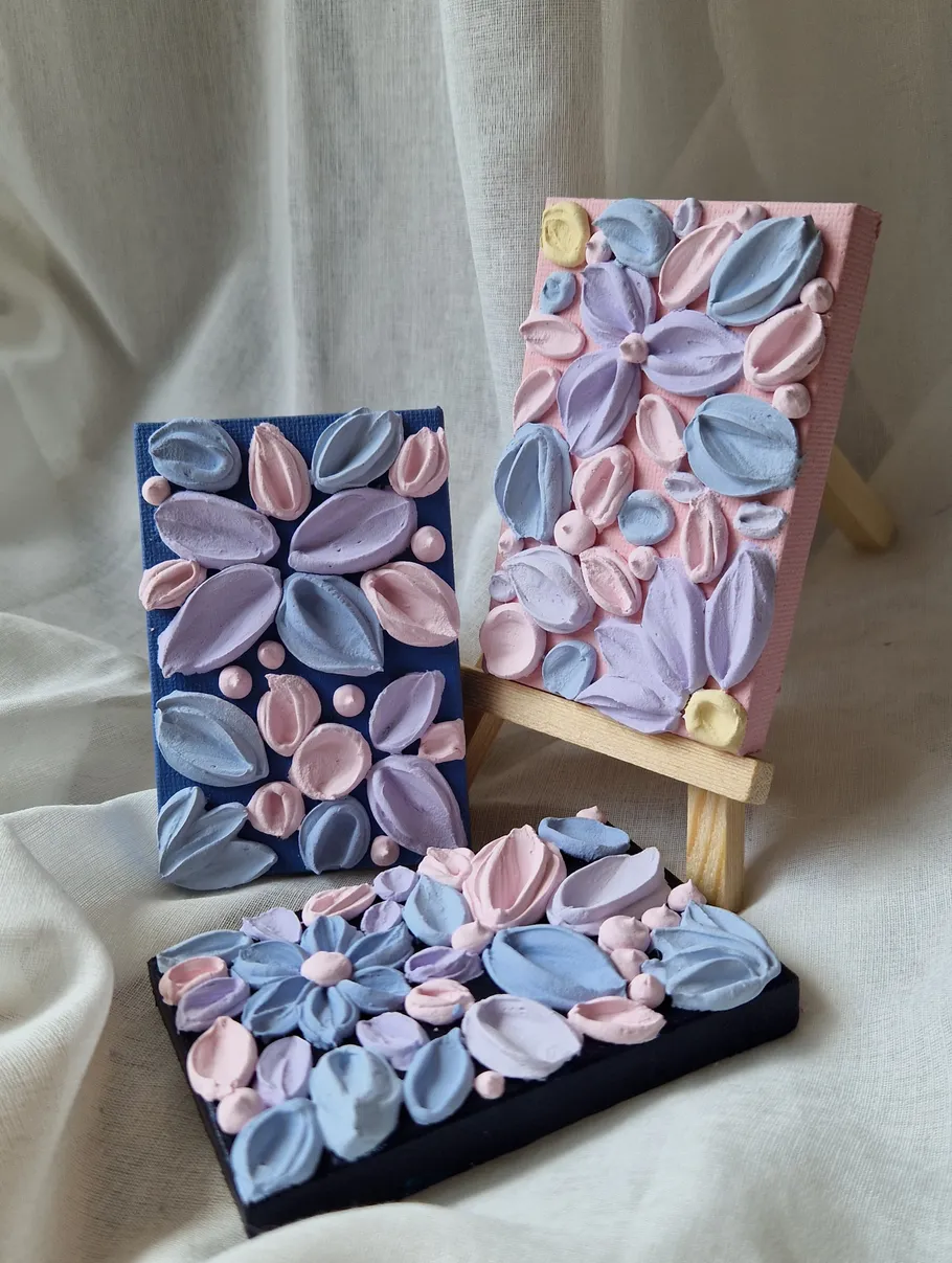 Textured colorful paintings on small easels.