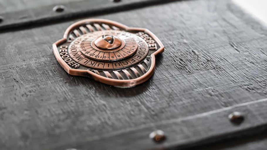Metal decoder wheel on wooden box surface.
