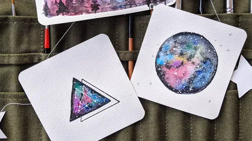 Farbige Aquarellbilder mit Galaxiemustern.