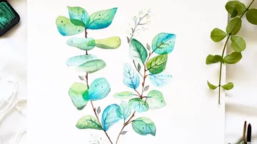 Watercolor painting of green leaves on paper.