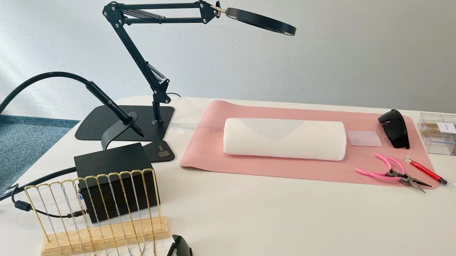 Jewelry workspace with tools and lamp.