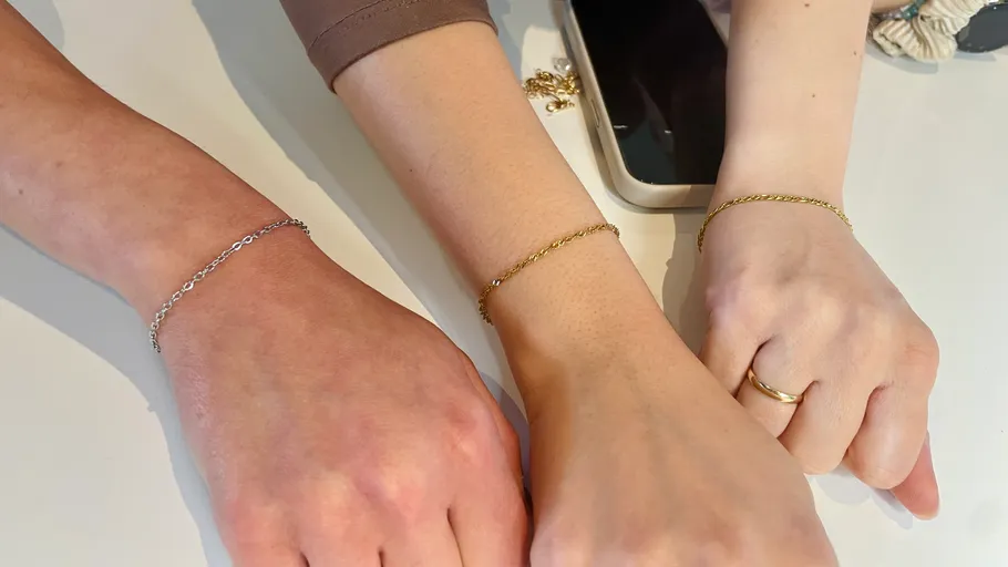 Drei Handgelenke mit zarten Armbändern gezeigt.