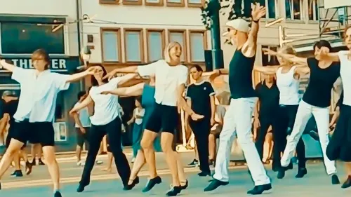 People dancing energetically on a street.