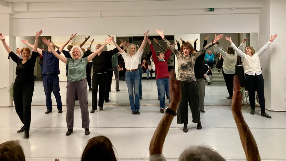 Group of people dancing in a studio.