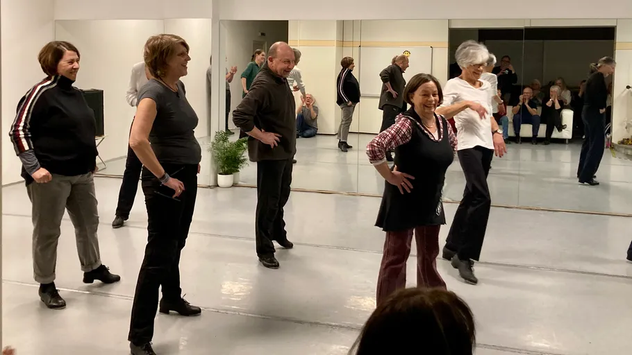 Group of people dancing in a studio.