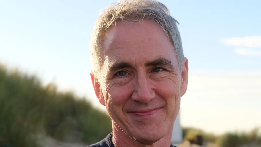 Smiling man outdoors on a sunny day.