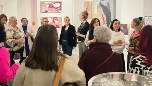 Group of women talking at art gallery.