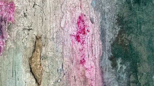 Textured wall with pink and green paint.