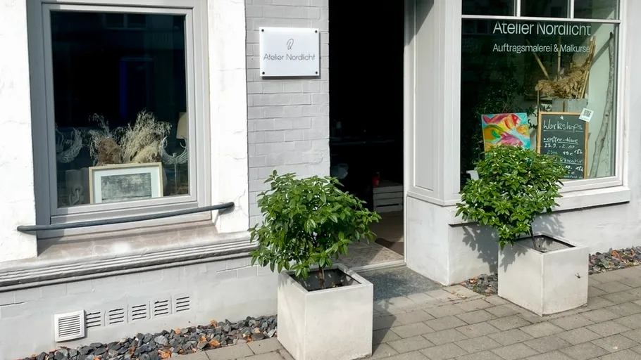 Kunststudioeingang mit Pflanzen draußen.